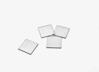 Four square single-crystal diamond plates on a white background.